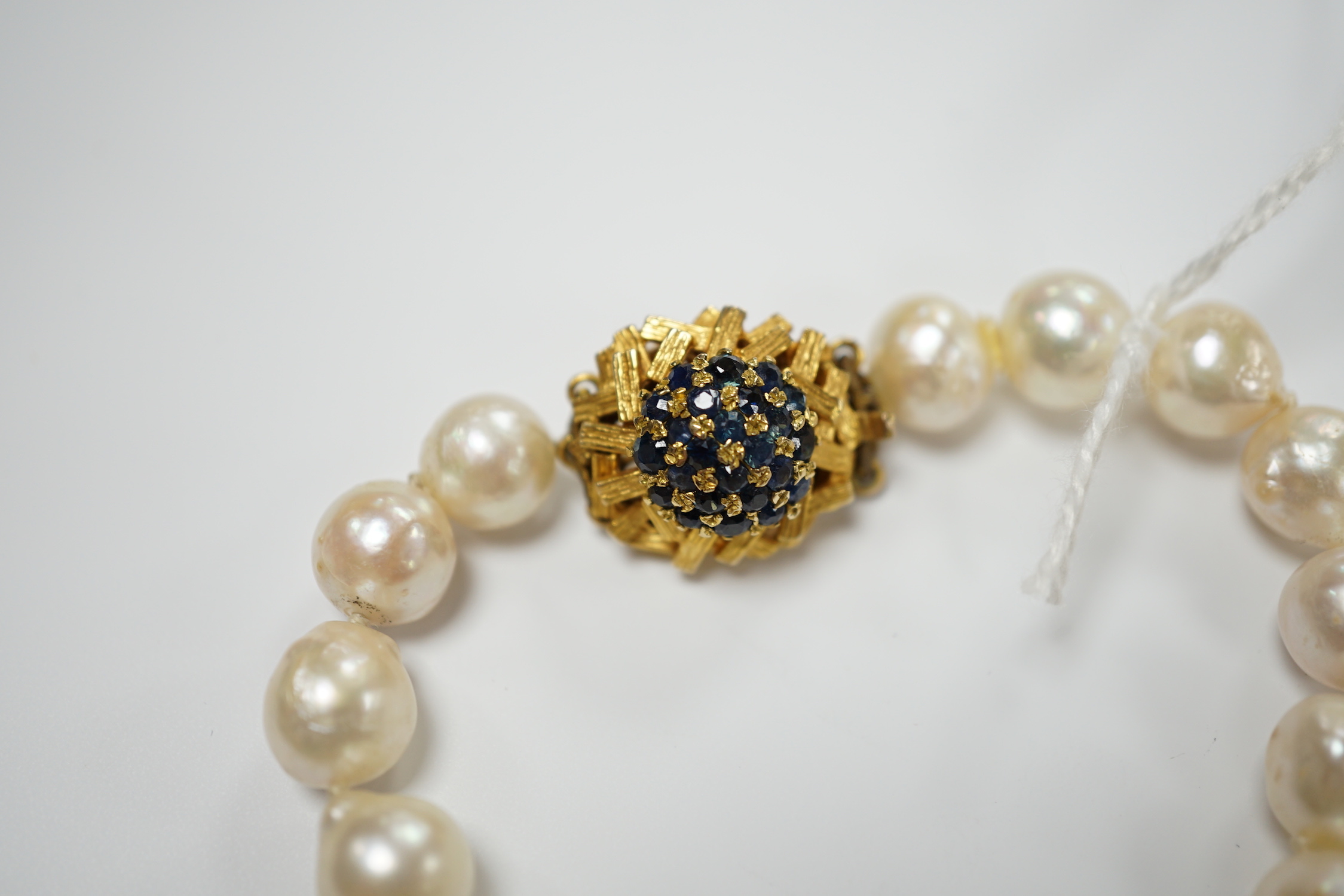 A modern single strand cultured baroque pearl necklace, with 9ct and sapphire set clasp, 66cm.